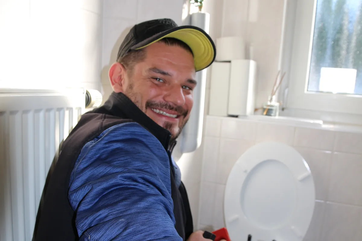 Monteur der Höfler GmbH bei der Rohrreinigung an einer Toilette