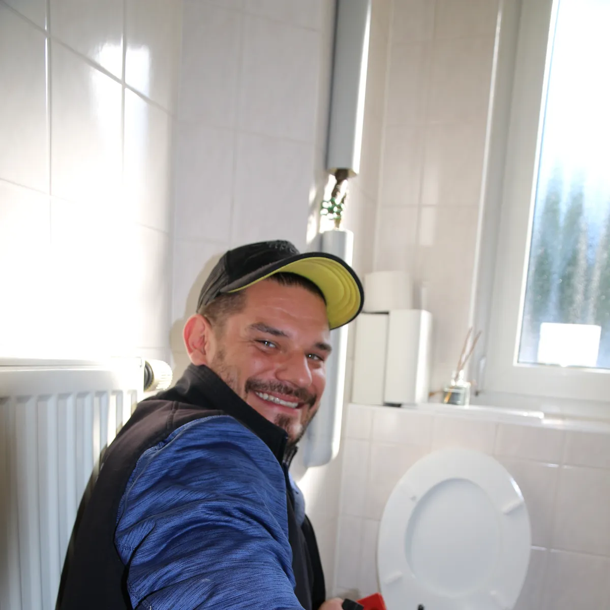 Monteur der Höfler GmbH mit Reinigungsspirale an einer verstopften Toilette